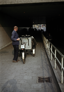 849777 Afbeelding van een medewerker van de gemeentelijke reinigingsdienst (?) met een bakfiets in de Leidseveertunnel ...